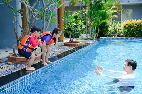 快乐的亚洲单身爸爸带着儿子和女儿在游泳池里玩耍 — 图库照片