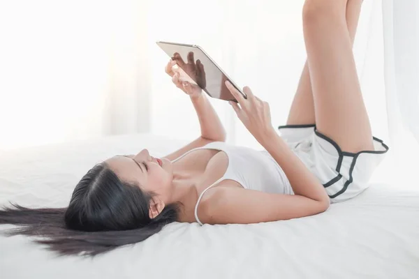 Asiatin Liegt Morgens Mit Tablette Auf Dem Bett — Stockfoto