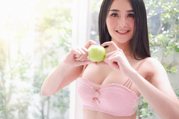 性感的亚洲女人穿着内衣裤或内裤 手里拿着绿色苹果 健康饮食理念 — 图库照片