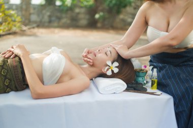 İki Asyalı seksi kadın açık havada spa masajı yapıyor.