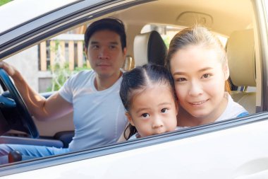 Mutlu Asyalı aile arabada oturuyor.