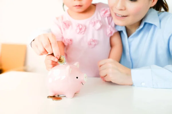 Asian Mother Daughter Inserting Coin Piggy Bank Select Focus Stock Picture