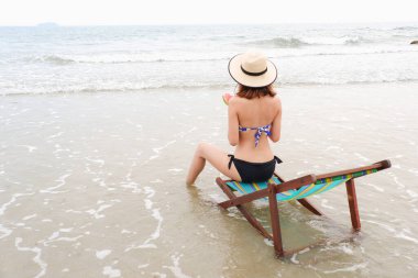 Sahilde bikini giyen seksi Asyalı kadın.