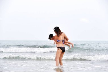 Asyalı bekar anne ve kızı kumsalda mutlu bir hayat, Rayong Tayland 'da deniz yolculuğu.