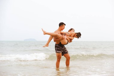 Asyalı aile babası, anne ve kızı sahilde sörf tahtasıyla mutlu bir hayat, Rayong Tayland 'da deniz yolculuğu.