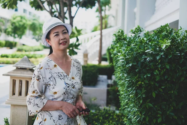 肖像画のシニアアジアの女性は庭で帽子をかぶって — ストック写真