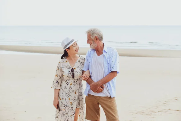 ポートレートアジアのシニア女性とCaucasian古いです男リラックス一緒にビーチで — ストック写真