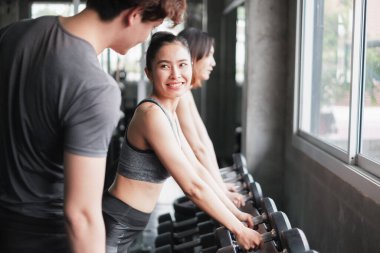 Asyalı grup arkadaşları spor yapıyor, spor yapıyor ve spor kıyafetlerini spor salonunda ya da spor salonunda giyiyorlar. Güç, spor ve kilo kaybı konsepti.