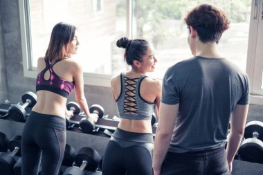 Asyalı grup arkadaşları spor yapıyor, spor yapıyor ve spor kıyafetlerini spor salonunda ya da spor salonunda giyiyorlar. Güç, spor ve kilo kaybı konsepti.