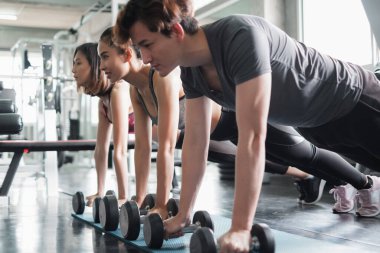 Asyalı grup arkadaşları spor yapıyor, spor yapıyor ve spor kıyafetlerini spor salonunda ya da spor salonunda giyiyorlar. Güç, spor ve kilo kaybı konsepti.