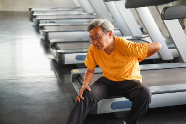 Spor salonunda koşu bandı koştuktan sonra Asyalı son sınıf öğrencisinin sırtı ağrıyor.