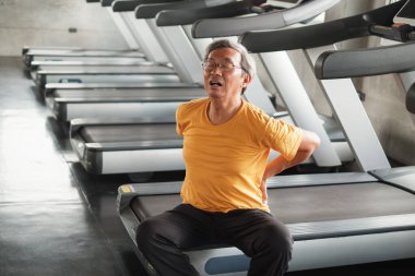 Spor salonunda koşu bandı koştuktan sonra Asyalı son sınıf öğrencisinin sırtı ağrıyor.