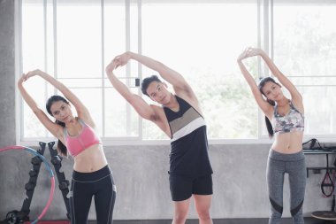 Asyalı grup arkadaşları spor yapıyor, spor yapıyor ve spor kıyafetlerini spor salonunda ya da spor salonunda giyiyorlar. Güç, spor ve kilo kaybı konsepti.