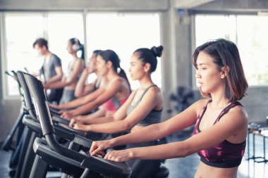 Asyalı grup arkadaşları spor bisikletleriyle spor kıyafetlerini spor ya da spor salonunda giyiyorlar. Güç, spor ve kilo kaybı konsepti.