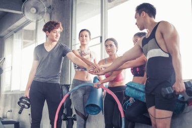 Gülümseyen Asyalı arkadaşlar, mutlu genç kadınlar ve erkekler spor merkezinde çalıştıktan sonra birlikte rahatlıyorlar, spor ve kilo verme konsepti.