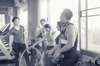 Gülümseyen Asyalı arkadaşlar, mutlu genç kadınlar ve erkekler spor merkezinde çalıştıktan sonra birlikte rahatlıyorlar, spor ve kilo verme konsepti.