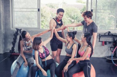 Gülümseyen Asyalı arkadaşlar, mutlu genç kadınlar ve erkekler spor merkezinde çalıştıktan sonra birlikte rahatlıyorlar, spor ve kilo verme konsepti.