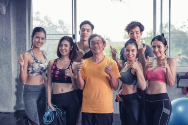 Asyalı son sınıf öğrencisi ve genç grup üyeleri spor salonunda farklı yaşlarda arkadaşlar.