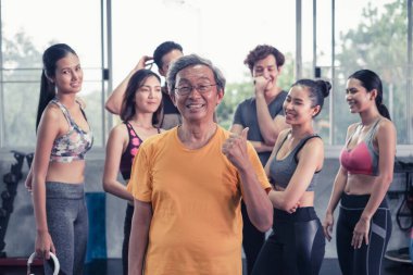 Asyalı son sınıf öğrencisi ve genç grup üyeleri spor salonunda farklı yaşlarda arkadaşlar.