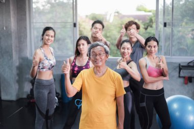 Asyalı son sınıf öğrencisi ve genç grup üyeleri spor salonunda farklı yaşlarda arkadaşlar.