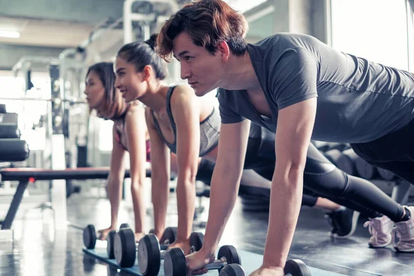 Asyalı grup arkadaşları spor yapıyor, spor yapıyor ve spor kıyafetlerini spor salonunda ya da spor salonunda giyiyorlar. Güç, spor ve kilo kaybı konsepti.