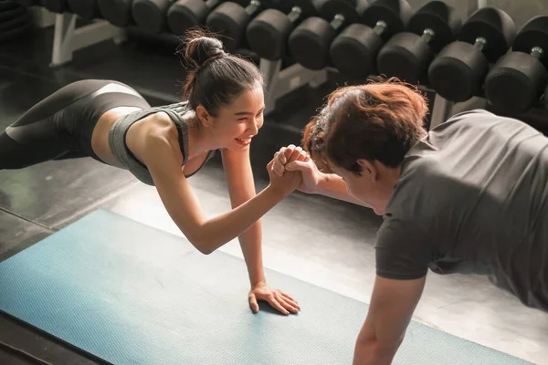 Asyalı grup arkadaşları spor yapıyor, spor yapıyor ve spor kıyafetlerini spor salonunda ya da spor salonunda giyiyorlar. Güç, spor ve kilo kaybı konsepti.