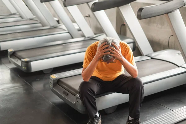 Spor salonunda koşu bandı koştuktan sonra Asyalı son sınıf öğrencisinin sırtı ağrıyor.