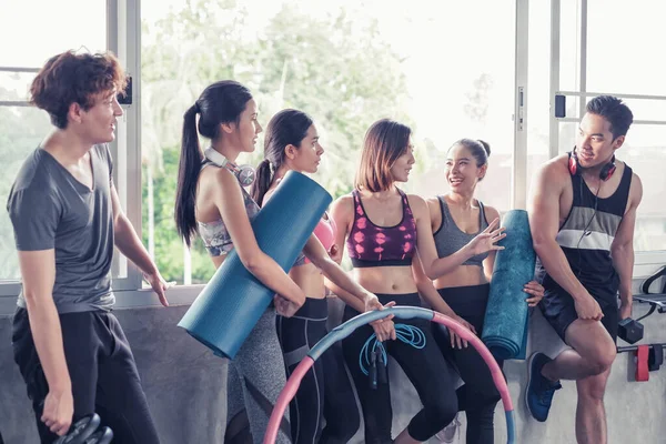 Gülümseyen Asyalı arkadaşlar, mutlu genç kadınlar ve erkekler spor merkezinde çalıştıktan sonra birlikte rahatlıyorlar, spor ve kilo verme konsepti.