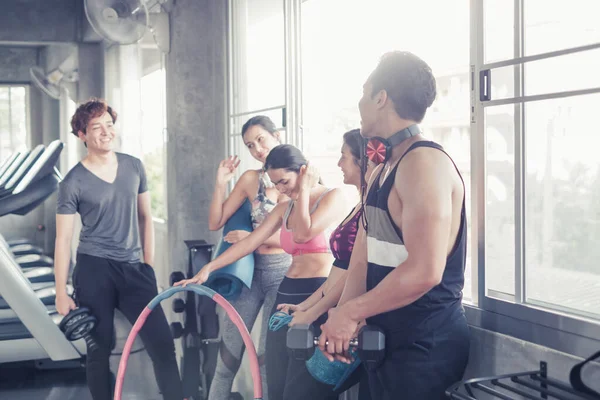 Gülümseyen Asyalı arkadaşlar, mutlu genç kadınlar ve erkekler spor merkezinde çalıştıktan sonra birlikte rahatlıyorlar, spor ve kilo verme konsepti.