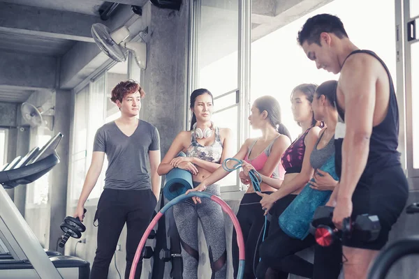 Gülümseyen Asyalı arkadaşlar, mutlu genç kadınlar ve erkekler spor merkezinde çalıştıktan sonra birlikte rahatlıyorlar, spor ve kilo verme konsepti.