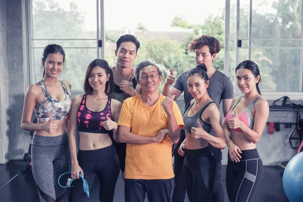 Asyalı son sınıf öğrencisi ve genç grup üyeleri spor salonunda farklı yaşlarda arkadaşlar.