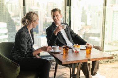 İki işadamı ve iş kadını çift, birlikte çalışmak için Sky Lounge 'da ya da ofiste buluşuyorlar.