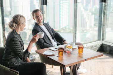 İki işadamı ve iş kadını çift, birlikte çalışmak için Sky Lounge 'da ya da ofiste buluşuyorlar.