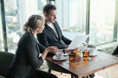 İki işadamı ve iş kadını çift, birlikte çalışmak için Sky Lounge 'da ya da ofiste buluşuyorlar.