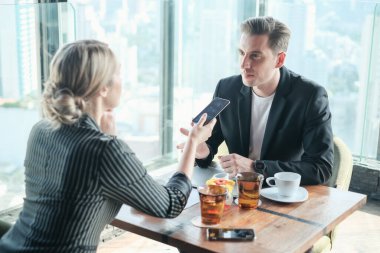 İki işadamı ve iş kadını çift, birlikte çalışmak için Sky Lounge 'da ya da ofiste buluşuyorlar.