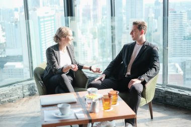İki işadamı ve iş kadını çift, birlikte çalışmak için Sky Lounge 'da ya da ofiste buluşuyorlar.