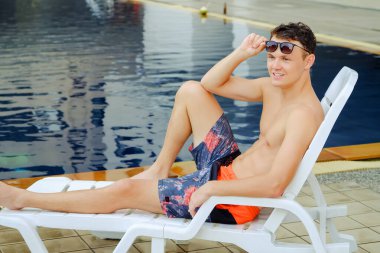 Havuz kenarında seksi beyaz bir adam portresi.