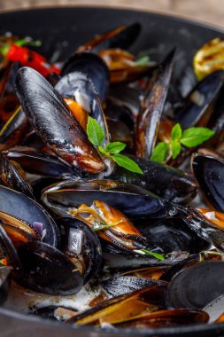 Kraft 'ta tavada midye, limon, biber ve şarap.