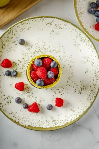 Fıstıklı, ahududulu ve yaban mersinli yeşil çörekler. Böğürtlen, hafif arkaplan.