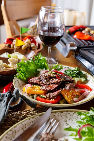 Sebzeli ızgara biftek, salata ve şarap, aperatifler.
