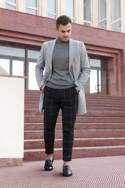 Gri sonbahar ceketli yakışıklı genç adam. Açık hava moda adamı portresi