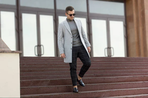 Bel giovanotto in cappotto grigio autunnale. Ritratto uomo moda outdoor — Foto Stock