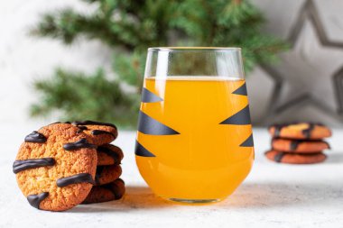 Siyah çizgili ve kurabiyeli, camlı turuncu mandalina kokteyli. Noel tatili içkisi. Çocuklar için ağaç dalları olan yeni yıl kavramı