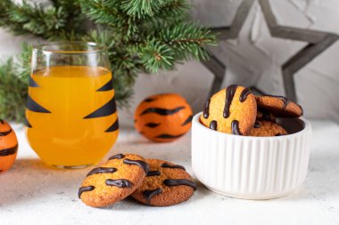 Siyah çizgili ve kurabiyeli, camlı turuncu mandalina kokteyli. Noel tatili içkisi. Çocuklar için ağaç dalları olan yeni yıl kavramı