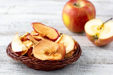 Ahşap zemin üzerinde kurumuş elma ve taze olgun elmalar yığını. Kurutulmuş meyve cipsi. Sağlıklı vejetaryen yemekleri