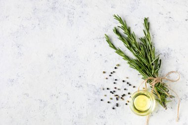 Açık beyaz arka planda biber, tuz ve yağlı bir demet yeşil biberiye. Tarifler için baharat ve bitkiler. Kopyalama alanı olan üst görünüm.