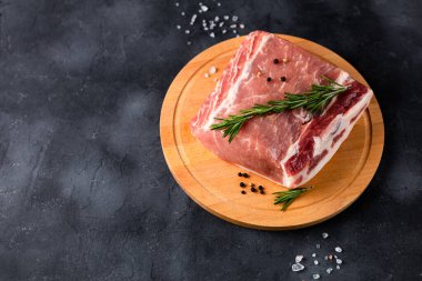 Kesme tahtasının üzerinde biberiyeli çiğ domuz eti. Tarifler ve yemek pişirmek için baharatlı et