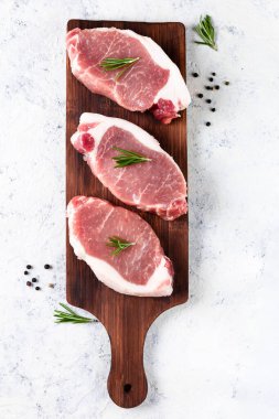 Hafif arka planda kesme tahtasına biberiyeli çiğ domuz eti. Yemek ve yemek tarifleri için baharatlı et. Üst görünüm