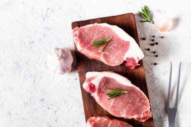 Hafif arka planda kesme tahtasına biberiyeli çiğ domuz eti. Yemek ve yemek tarifleri için baharatlı et. Kopyalama alanı olan üst görünüm