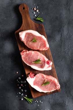 Kesme tahtasının üzerinde biberiyeli çiğ domuz eti. Yemek ve yemek tarifleri için baharatlı et. Üst görünüm